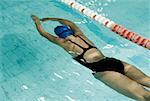 Rear view of a teenage girl swimming in a swimming pool