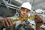 Portrait of a male construction worker holding a tape measure