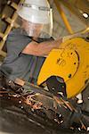 Male construction worker working on an electric saw at a construction site