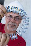 Portrait of a male construction worker folding a metal spring and smiling