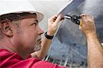 Side profile of a male construction worker working with a wrench