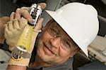 Close-up of a male construction worker holding a tape measure