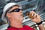 Close-up of a male construction worker talking on a walkie-talkie