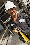 Portrait of a male construction worker holding a tape measure and smiling