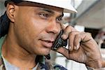 Gros plan d'un mâle ouvrier parlant sur un téléphone mobile