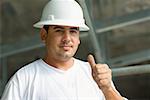 Portrait d'un travailleur de la construction mâle montrant un pouce levé signe