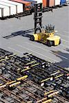 High angle view of a forklift with vehicle trailers and cargo containers at a commercial dock