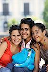 Portrait of three young women sitting and smiling