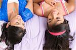 High angle view of a young woman and a teenage girl lying on the bed and smiling