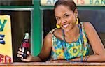 Portrait of a young woman leaning on a railing and holding a cola bottle