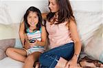 Mid adult woman sitting with her daughter on a couch