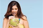 Close-up of a young woman drinking coconut milk and smiling