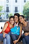 Portrait of three young women sitting and smiling