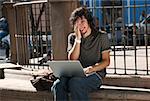 Close-up of a young man using a laptop and smiling