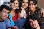 Portrait de trois jeunes femmes et deux jeunes hommes assis ensemble