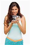 Portrait of a young woman holding a mug of coffee and smiling