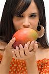 Portrait d'une jeune femme tenant une mangue