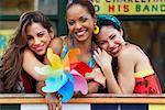 Portrait of three young women smiling and holding a pinwheel