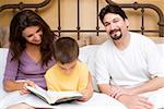 Mid adult woman teaching her son with a mid adult man sitting beside them