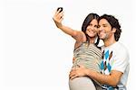 Close-up of a young couple taking a photograph of themselves with a mobile phone