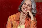 Close-up of a senior woman smiling with her hand on her chin