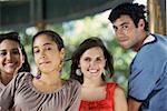 Portrait d'un jeune homme avec trois jeunes femmes posant et souriant