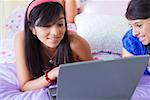 Adolescente et jeune femme regardant un ordinateur portable et souriant