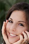 Portrait d'une jeune femme souriante avec ses mains sur son menton