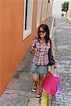 Jeune femme transportant des sacs à provisions et à l'aide d'un téléphone mobile, le vieux San Juan, San Juan, Puerto Rico