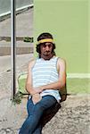 Young man leaning against a wall and thinking