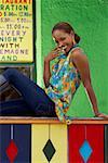 Portrait of a young woman sitting on a railing and smiling