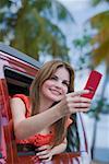 Young woman taking a picture with a mobile phone and looking away