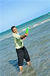 Mid adult man playing with a plastic disc on the beach