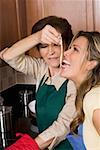 Senior Woman Fütterung Nudeln an ihre Tochter in der Küche