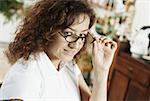 Portrait d'une femme mature furtivement sur ses lunettes