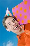 Portrait of a boy holding a birthday present and laughing