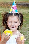 Portrait d'une jeune fille mangeant un petit gâteau