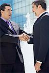 Side profile of two businessmen shaking hands