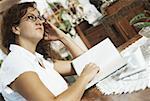 Side profile of a mature woman reading a book and thinking