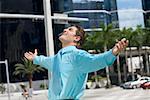 Side profile of a businessman standing with his arms outstretched