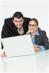Porträt eines Kaufmanns und einer geschäftsfrau lächelnd vor einem laptop