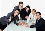 Portrait of two businesswomen and three businessmen placing their hands on the table