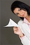 Portrait of a businesswoman holding a paper airplane