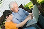 Senior homme avec son petit-fils à l'aide d'un ordinateur portable
