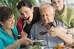 Senior couple having lunch with their grandchildren