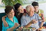 Senior couple having lunch with their grandchildren