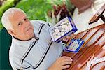 Portrait of a senior man holding a box of dominos