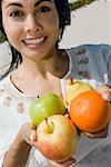 Portrait d'une femme adulte mid holding fruits et souriant