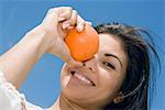 Portrait d'une femme adulte mid tenant une orange et souriant