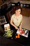 Porträt von einem senior Woman schneiden Gemüse auf ein Schneidebrett in der Küche